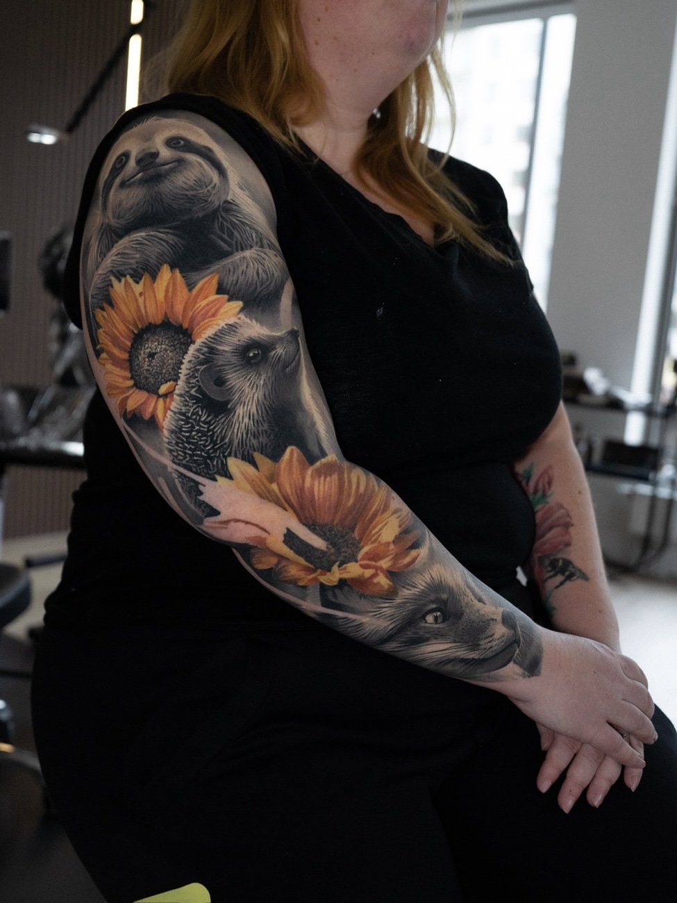 Realism-sleeve i färg med en solros och ett porträtt