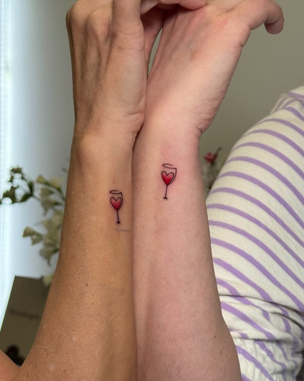 Matchande fine line-tatueringar av ett rött vinglas